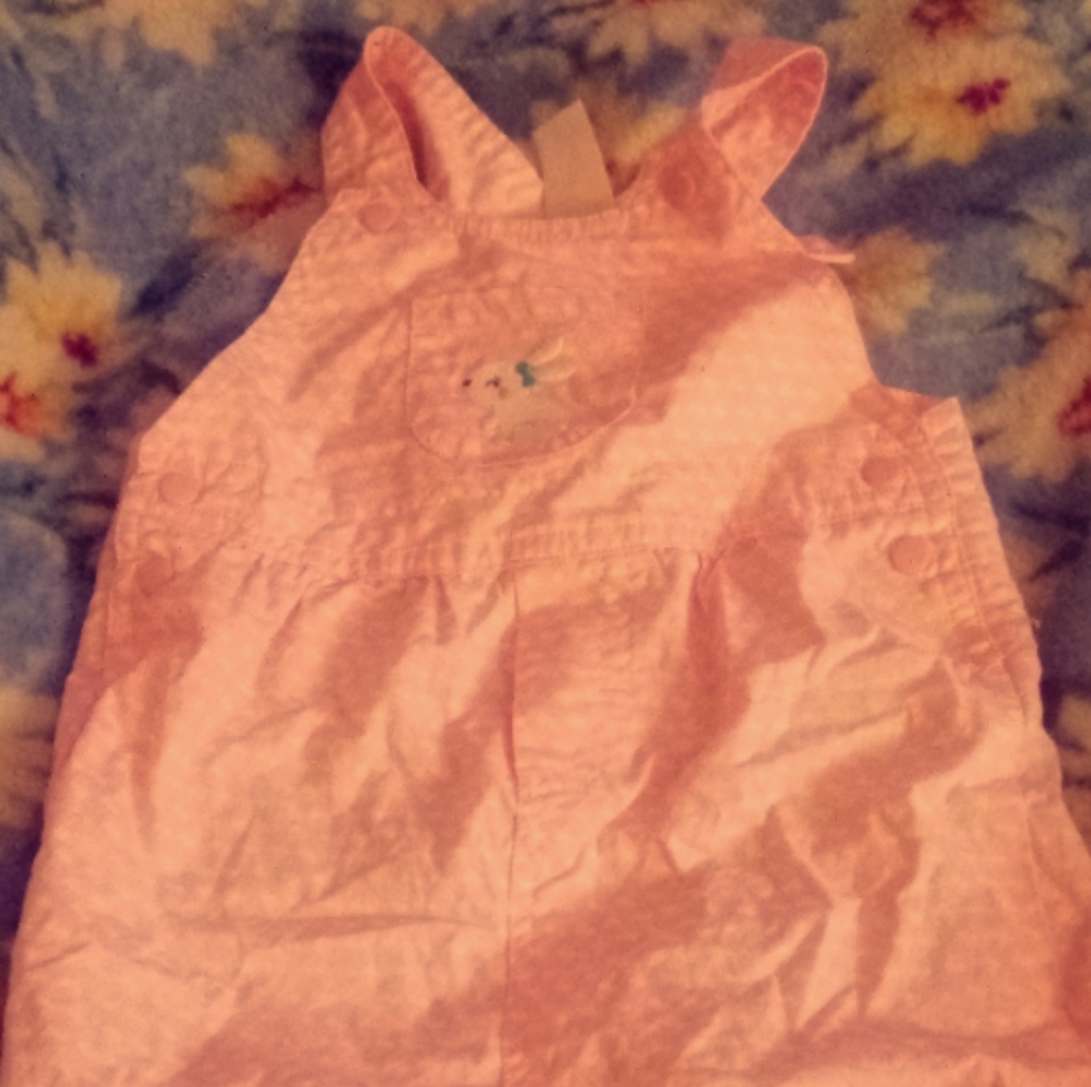 This is a pink baby overalls with little white bunnies on it